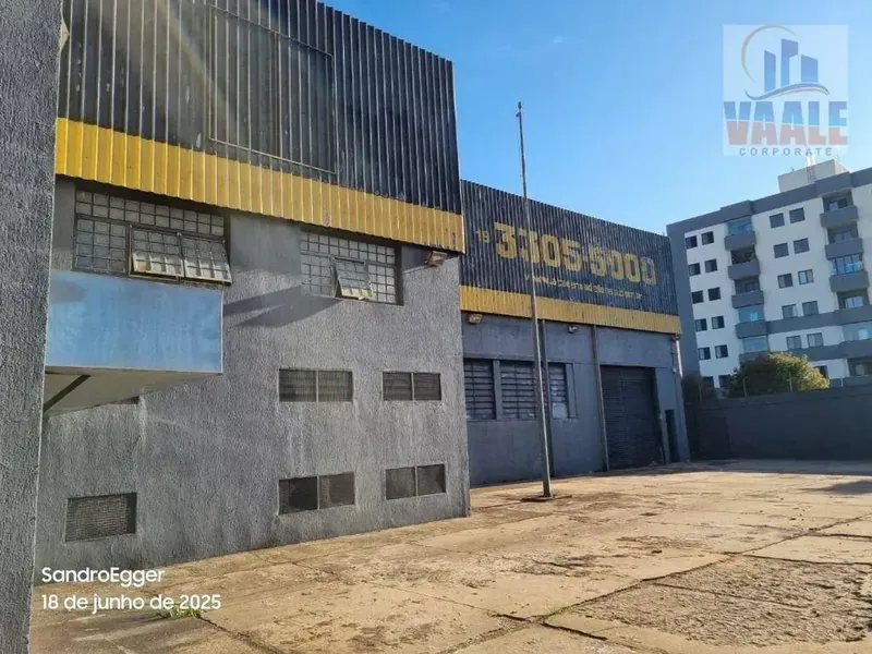Fachada do galpão com portões de acesso e pátio